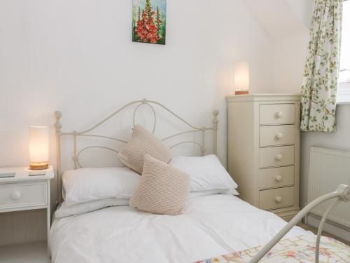 um quarto com uma cama branca e 2 almofadas em Little Daisy Cottage em Hornsea