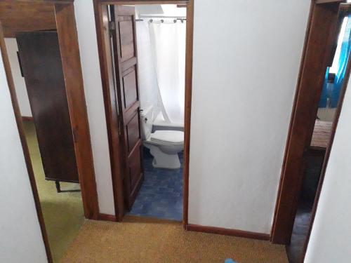 a bathroom with a toilet and a mirror at Las Verbenas Hotel in La Cumbrecita