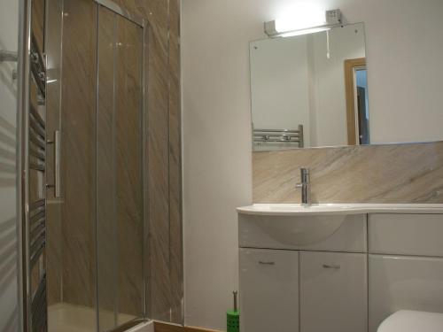 uma casa de banho com um lavatório e um espelho em Seagulls Perch em Mawgan Porth