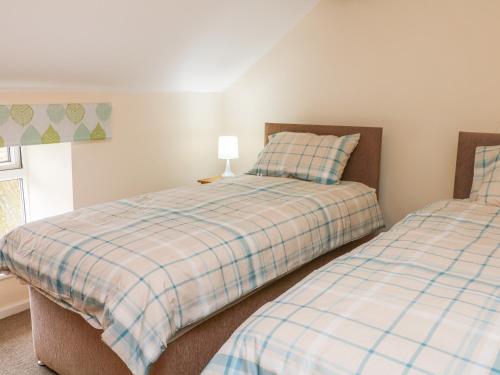 a bedroom with two beds and a lamp at Stone Farm Cottage in Sheffield