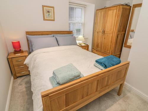 una camera da letto con un grande letto con due asciugamani di Flat 2 Galloway House a Kendal