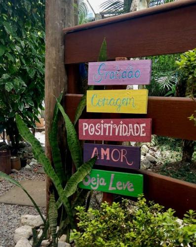 a group of signs on a fence in a garden at Pousada Gaucha Caiobá in Matinhos