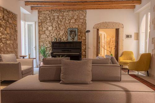 a living room with a couch and chairs and a mirror at Isabella di Castiglia Apartments in Siracusa