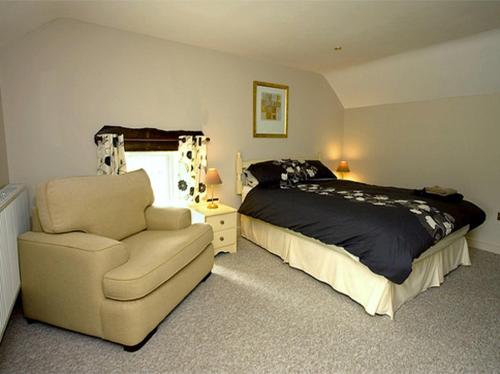 a bedroom with a bed and a chair and a couch at The Rindle in Leek