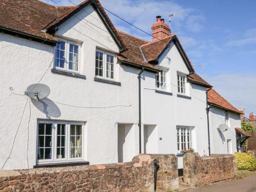 a white house with a satellite at 3 Elm Cottage in Minehead