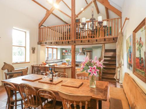 a kitchen and dining room with a wooden table and chairs at The Barn in Honiton