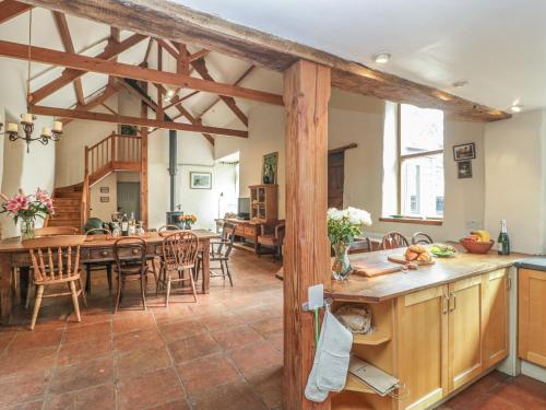 a kitchen and living room with a table and chairs at The Barn in Honiton
