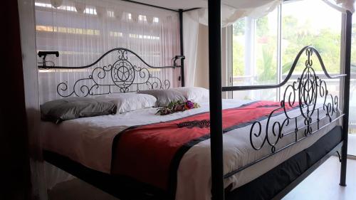 a bedroom with a bed with a wrought iron headboard at VILLA ZENITUDE DES SALINES in Le Gosier