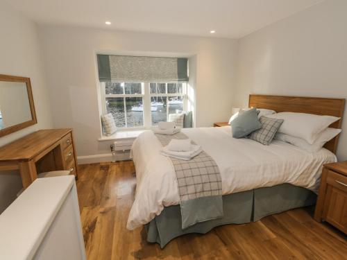 a bedroom with a large bed and a window at Pennington in Ambleside