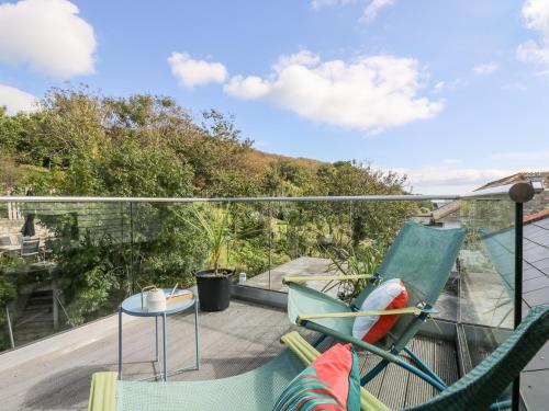 a balcony with two chairs and a table on a roof at The Upper Deck in Penzance