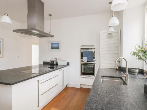 a kitchen with white cabinets and a counter top at The Upper Deck in Penzance