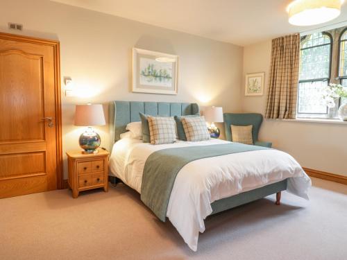 a bedroom with a bed and a chair and a window at Apartment 1 St Mary's Church in Moffat