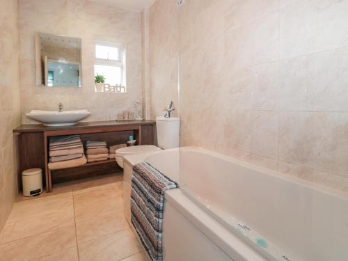 a bathroom with a tub and a sink and a toilet at Bracken Barn Cottage in Morpeth