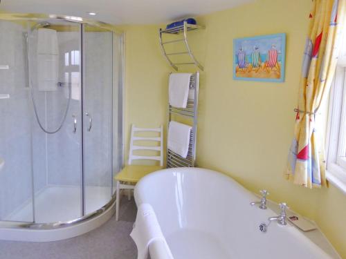 een badkamer met een bad, een douche en een wastafel bij Balcony Cottage in Cawsand