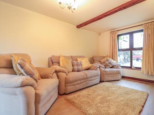 a living room with two couches and a window at Berrys Place Farm Cottage in Gloucester