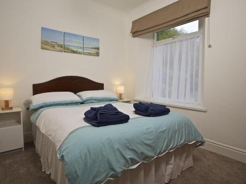 a bedroom with a bed with two blue towels on it at Cove View in Kingsbridge