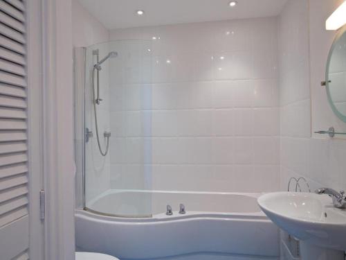 a bathroom with a shower and a tub and a sink at Cove View in Kingsbridge