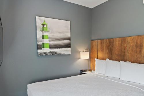 a bedroom with a bed and a picture of a lighthouse at Extended Stay America Premier Suites - Phoenix - Chandler - Downtown in Chandler