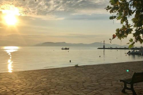 a sunset over a lake with a boat in the water at CASA LELA 1...όπως μια φορά...like once in Míloi