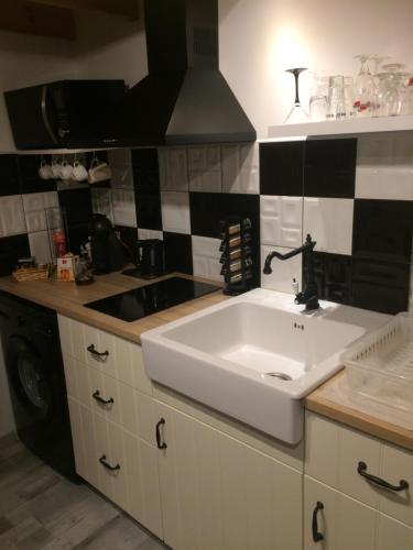 スーストンにあるLoft Zenの白いシンクと黒と白のタイルが施されたキッチン