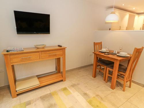 a living room with a table and a television on the wall at Frost in Ambleside