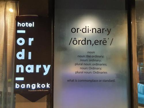 Hotel Ordinary Bangkok في بانكوك: لافتتان على باب زجاجي مع كلمة فندق أو abey jorkey