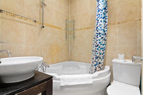 W łazience znajduje się umywalka, toaleta i prysznic. w obiekcie Spacious 3 Bed Flat with Balcony in Kensington for 6 people w Londynie