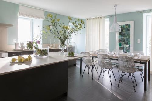 a kitchen with a dining table and chairs at La Bourgeoise in Portbail