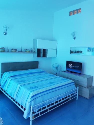 サンタ・テレーザ・ガッルーラにあるCasa Vacanze Danielaのベッドルーム1室(ベッド1台、青い照明付)