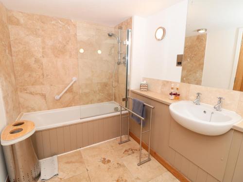 a bathroom with a tub and a sink and a shower at 5 Harbour Yard in Salcombe