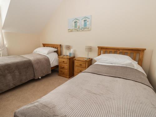 ein Schlafzimmer mit zwei Betten und zwei Nachttischen in der Unterkunft Pebble Cottage Dunnscroft in Bridlington