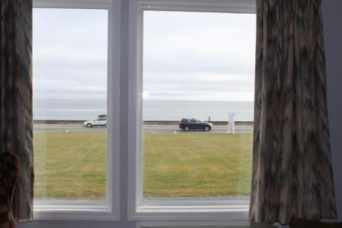 a window with a view of a car on a highway at The Atlantic House in Narragansett