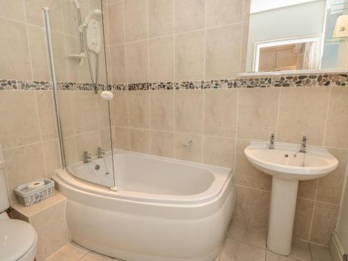 een badkamer met een toilet, een bad en een wastafel bij 5 Island Street in Salcombe