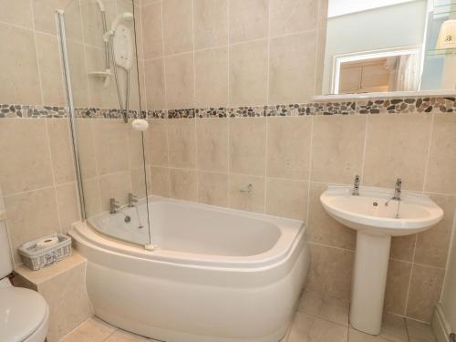 a bathroom with a toilet and a tub and a sink at 5 Island Street in Salcombe