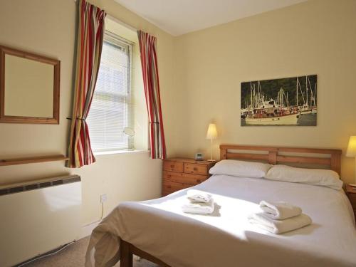 um quarto com uma cama com toalhas em Columbine em Dartmouth