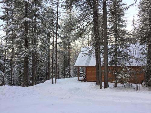 a log cabin in the woods in the snow at The Ridge At Glacier - Luxury Cabins in Coram
