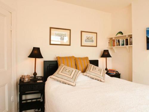 ein Schlafzimmer mit einem Bett mit zwei Kissen darauf in der Unterkunft The Cottage, 13 Clarence Hill in Dartmouth