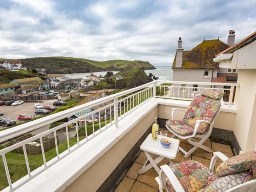 a balcony with chairs and a table and the ocean at 5 Chichester Court in Kingsbridge