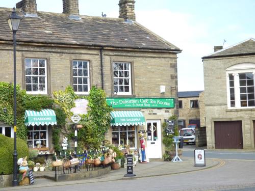 an old brick building with a sign in front of it at Woodpecker Lodge in Skipton