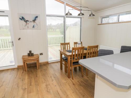 a kitchen and dining room with a table and chairs at Woodpecker Lodge in Skipton