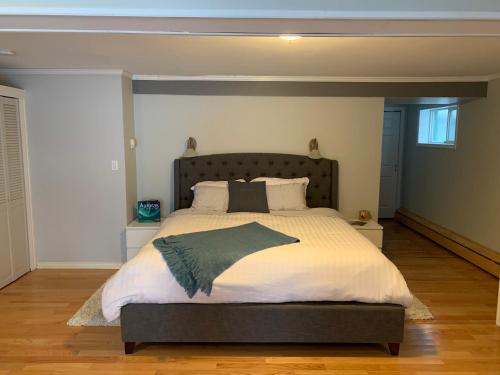 a bedroom with a large bed with a gray headboard at Great Slave Lakeside Bed & Breakfast in Yellowknife