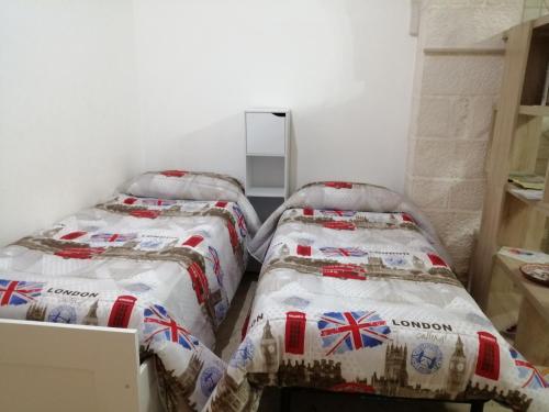 two beds sitting next to each other in a room at Casa Nino in Martina Franca