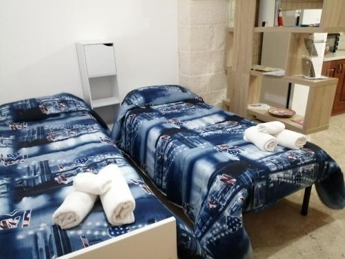 マルティナ・フランカにあるCasa Ninoの青い掛け布団付きの客室内のベッド2台