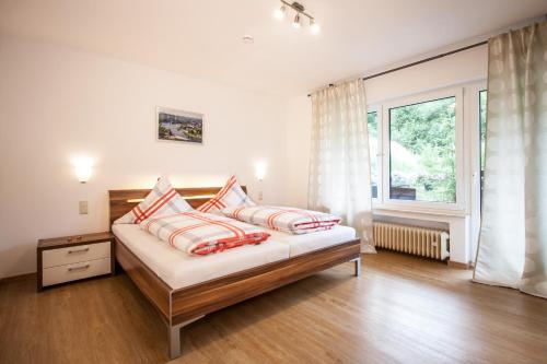 1 dormitorio con 1 cama con 2 almohadas y ventana en Das Moseltor zu Koblenz en Lehmen