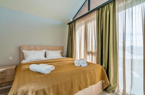 古道里的住宿－GVC 3-room 2-level apt New Gudauri，一间卧室配有一张床,上面有两条毛巾
