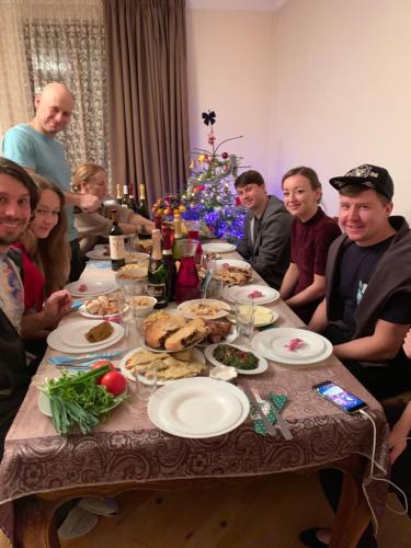 a group of people sitting around a table with food at Manana Japaridze's Guesthouse in Mestia