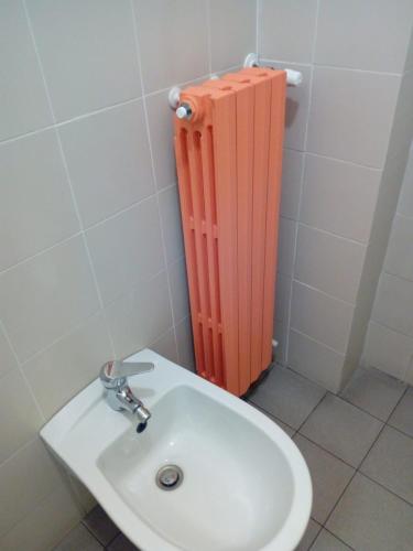 a bathroom with a sink and a red radiator at Tigullio Vacations Il Ciliegio Apartment in Leivi