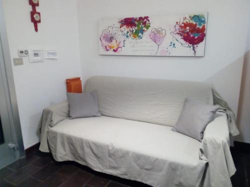 a white couch in a room with a painting on the wall at Tigullio Vacations Il Ciliegio Apartment in Leivi