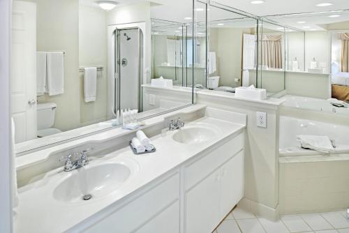 a white bathroom with two sinks and a large mirror at Greensprings Vacation Resort in Williamsburg