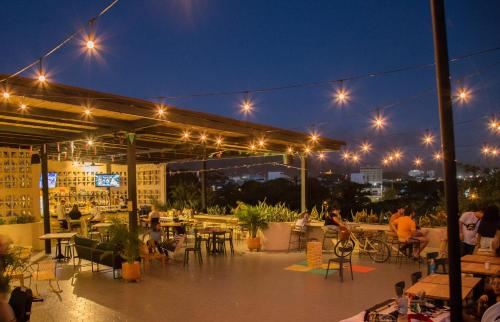 a patio with lights and people sitting at tables at Viajero Santa Marta Hostel in Santa Marta